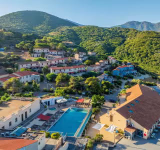 Vue aérienne de la résidence et de sa piscine, au pied des collines