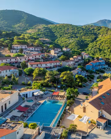 Vue aérienne de la résidence et de sa piscine, au pied des collines