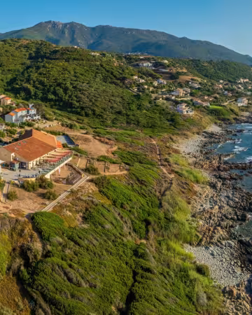 Vue aérienne du Paese Di Lava, à flanc de colline au-dessus de la côte rocheuse du golfe de Lava